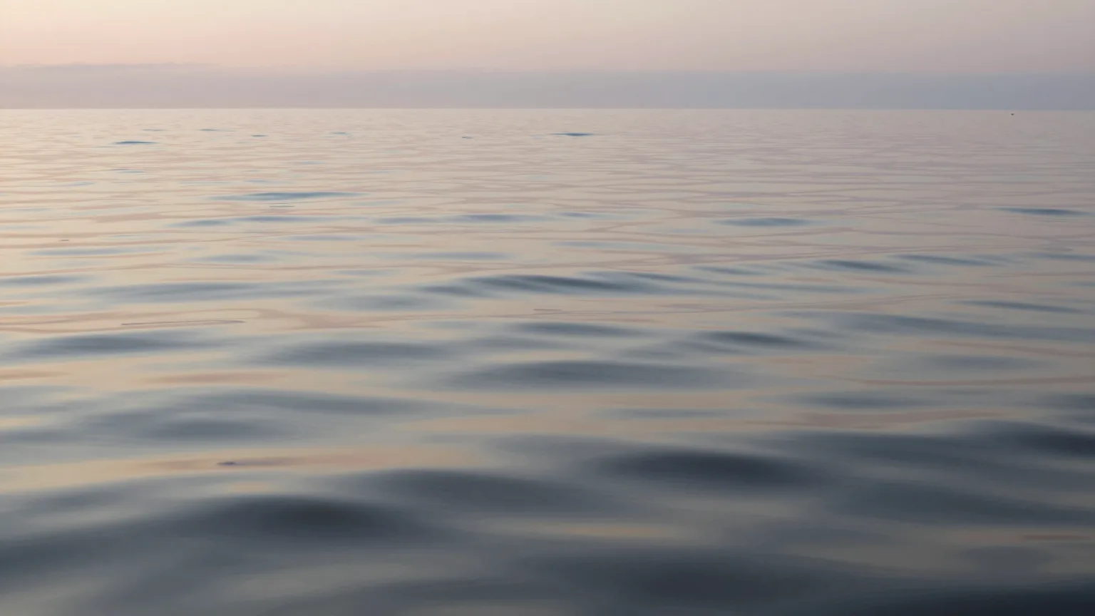 Ruhige Wasserfläche mit weitem Horizont im Abendlicht
